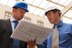 two architects reviewing blueprints